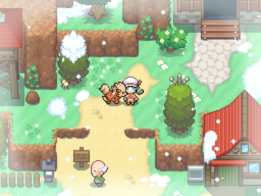 A trainer and following Pokemon stand on a village path amid snow patches and evergreen trees.