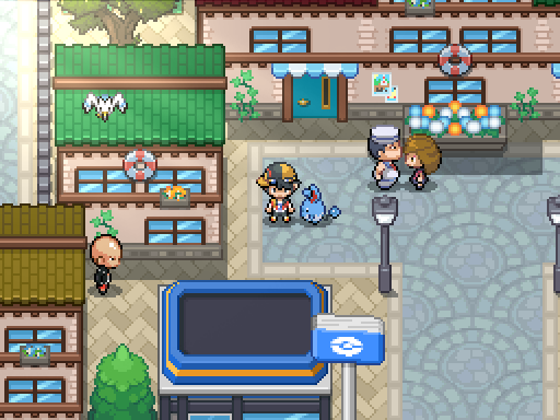 A trainer and following Pokemon stand beside flower-decorated shops and a streetlamp.